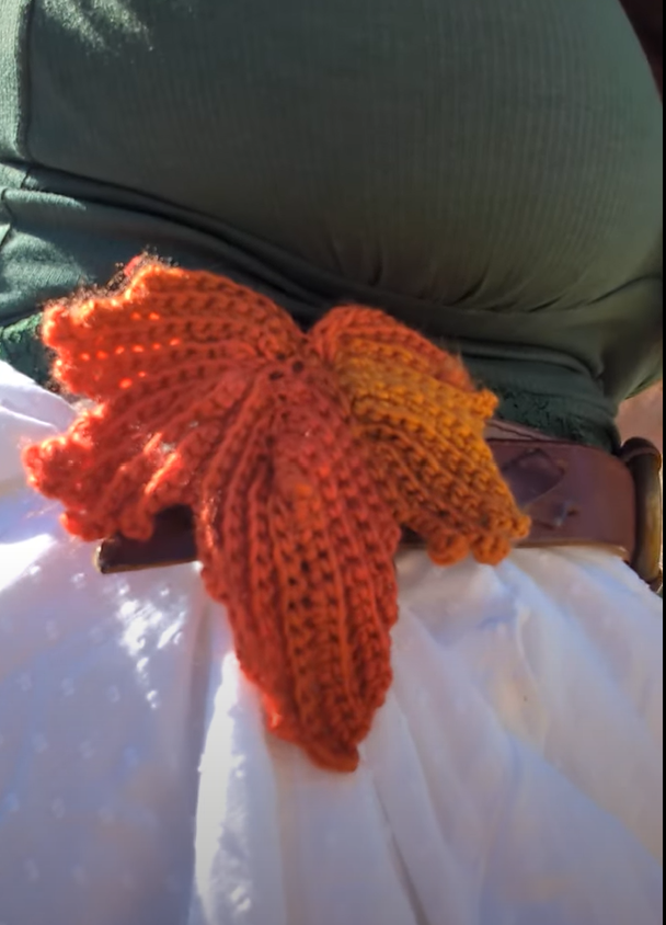 Crocheted fall leaf mounted on a belt, holding up a white skirt