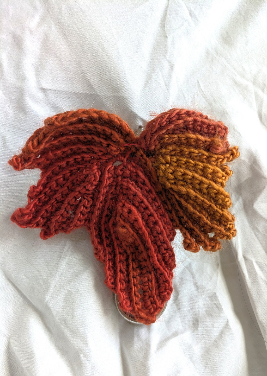 Crocheted fall leaf mounted on a belt, holding up a white skirt