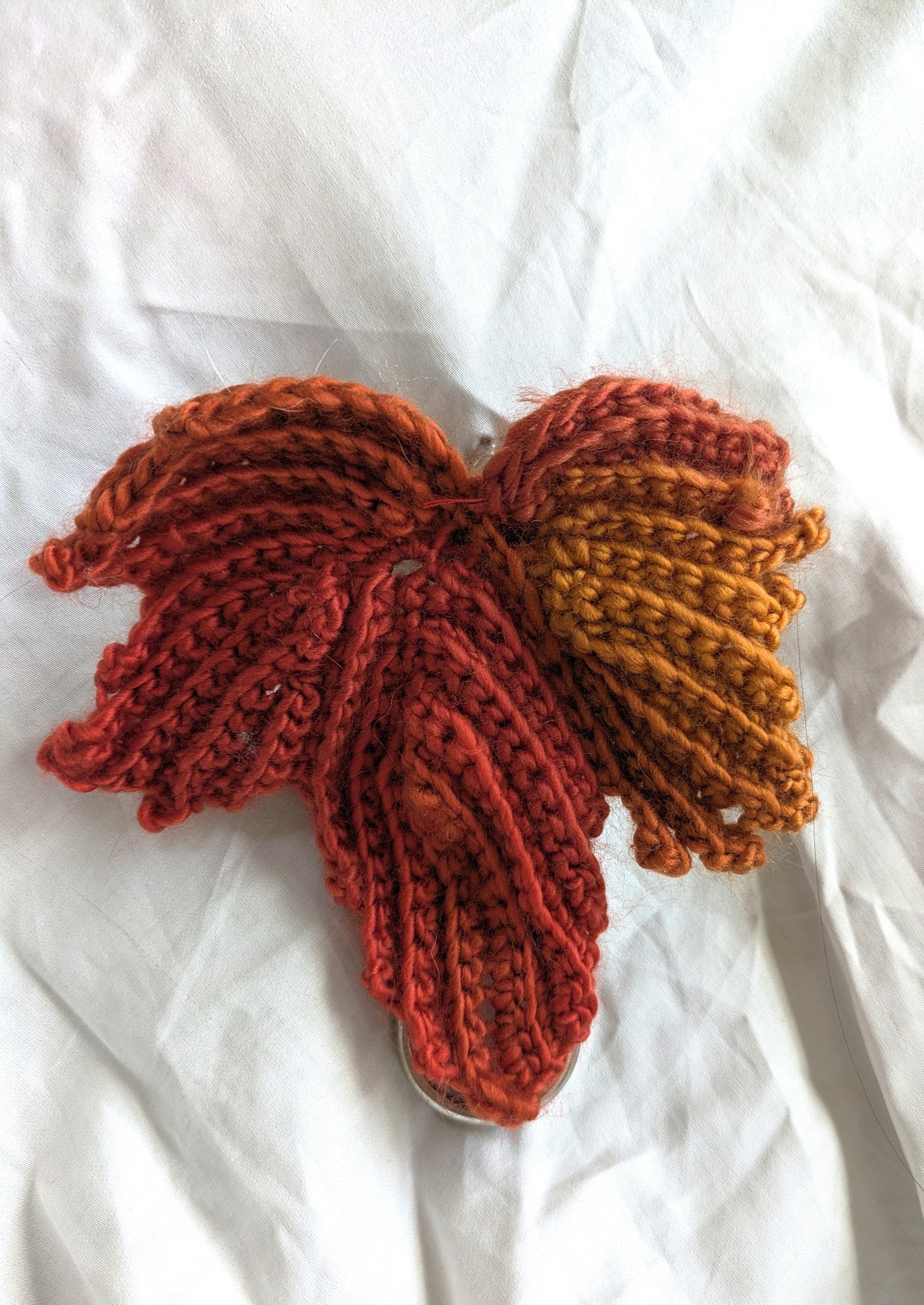 Crocheted fall leaf mounted on a belt, holding up a white skirt