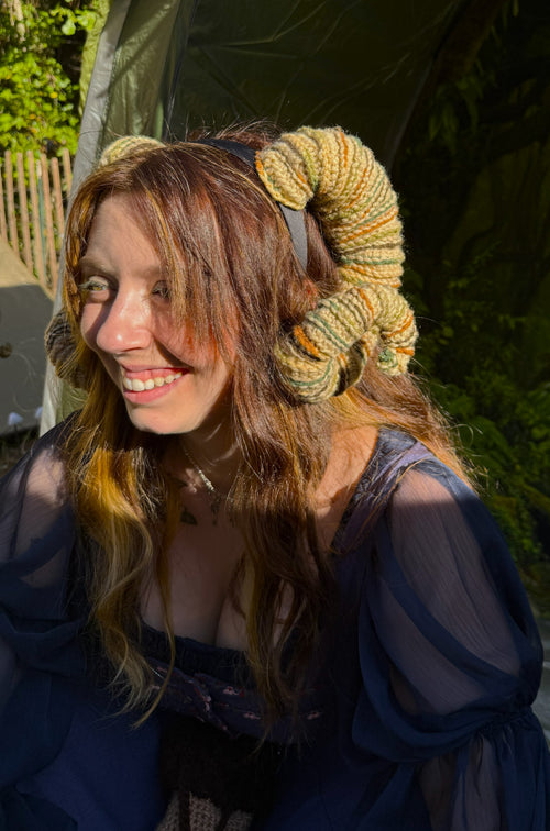 Woman wearing a large knitted headband outdoors
