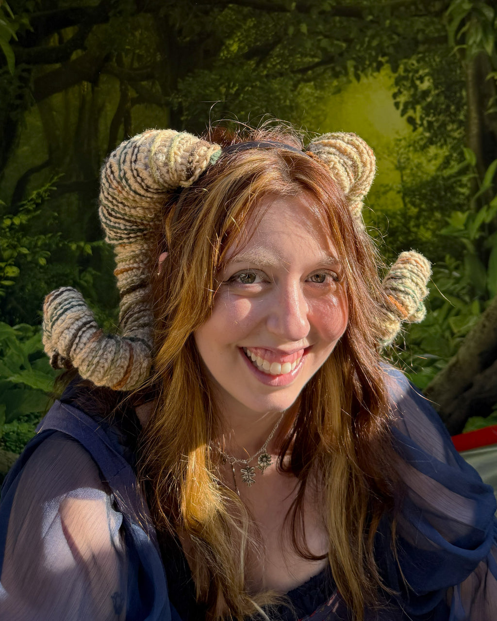 Person wearing ram horns in a forest setting